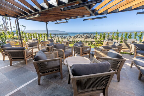 The outdoor patio features teak lounge chairs and stunning waterfront views.