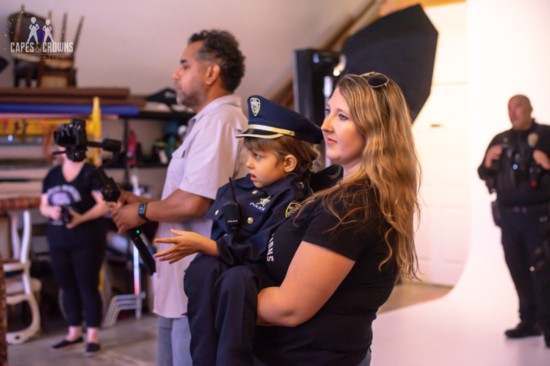 Capes & Crowns Foundation Founder Kylie Cole with an aspiring police officer.