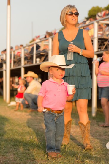 A cowboy enjoys a treat a rodeo.
