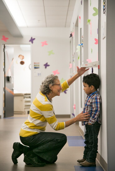 A pediatric patient being measured by one of the staff physicians.