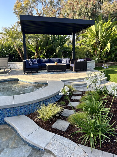 Adding a custom fire feature, two large pergolas and an arbor, plus a dining space to accommodate a large extended family reimagined a tired and dated backyard.