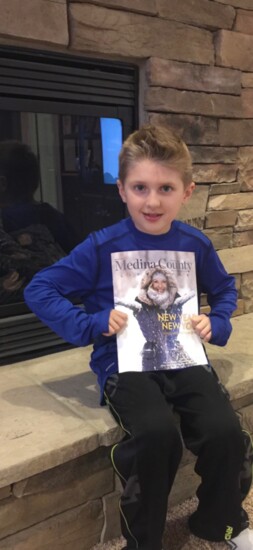 Luca Violi, son of Medina County Lifestyle publisher Joe Violi, holding the January 2016 issue.