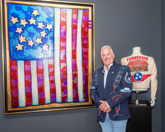 Tim Yanke poses by one of his American flag paintings.