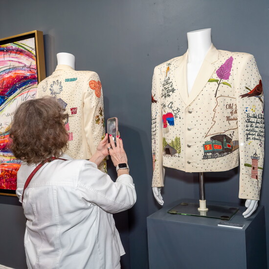 A visitor photographs jackets by Manuel Cuevas during the opening night of the For the Love of Liberty exhibition.