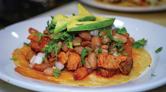 Taco Shore's Taco Al Pastor features a slow-simmered pork shoulder cooked with traditional Mexican spices, citrus juices, and sweet pineapple.