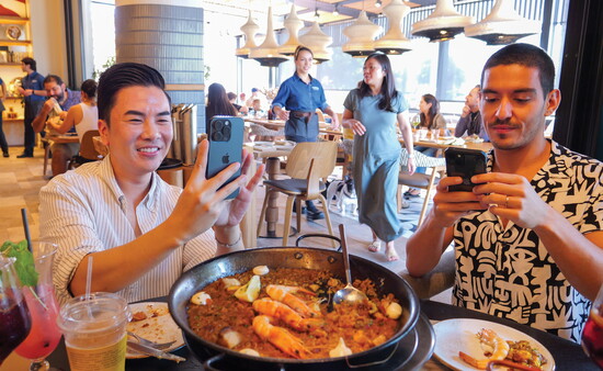 Foodies snap photos as they share Telefèric Barcelona’s Paella Mixta, served in it's own paellera.