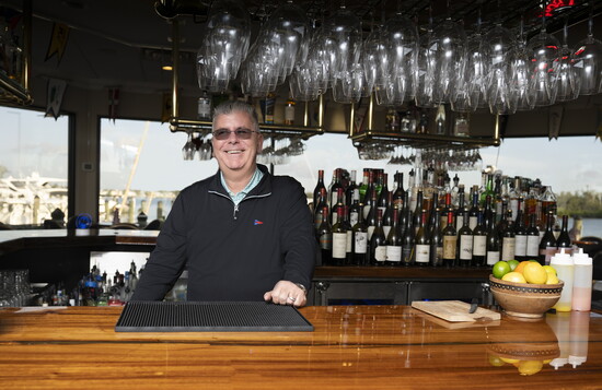 VYC’s GM/CEO Ed Tindall behind the bar is ready to celebrate. 