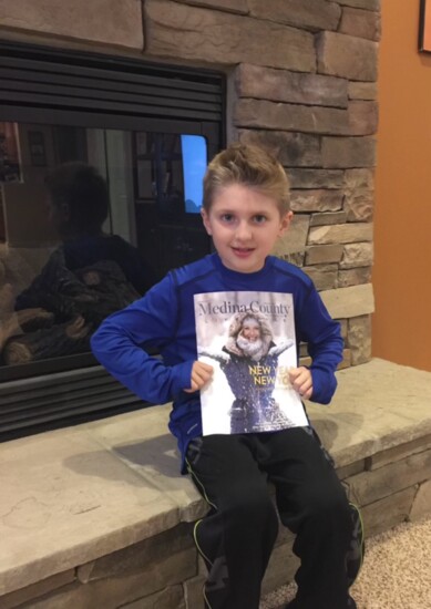 Our publisher Joe Violi's son, Luca, holding the first issue of Medina County Lifestyle.