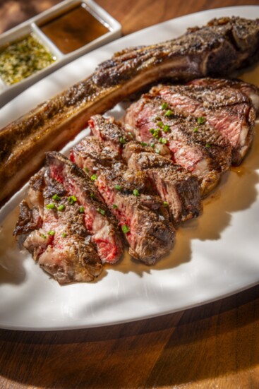 Tomahawk Ribeye—Thirty-two ounces of prime meat prepared gluten-free with rosemary truffle butter, bone marrow demi + Alara's chimichurri.