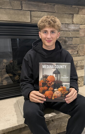 Lucca Violi, son of Medina County Lifestyle publisher Joe Violi, holding an issue of the magazine in November 2025.