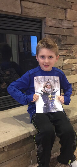 Luca Violi, son of Medina County Lifestyle publisher Joe Violi, holding the very first issue of the magazine in January 2016