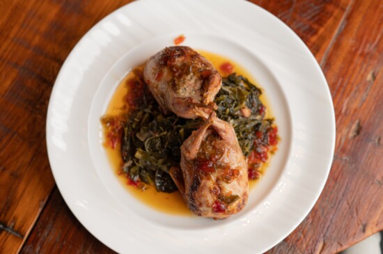 Quail stuffed with house boudin finished with bacon collard greens and topped with pepper jelly glaze. 