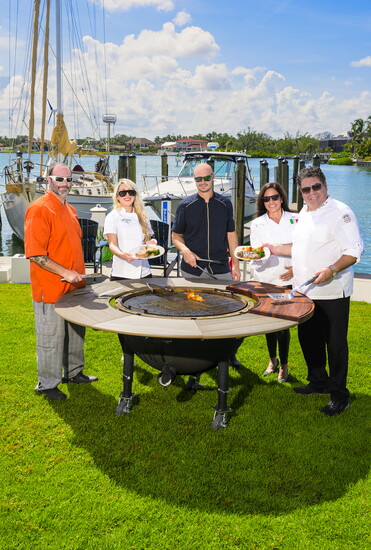 Chefs Bryan Meek, Ashley Lauren, Steven Longet, Epicurean Director Judy Gaspar and Chef Jimmy Nadell, gather by the fire pit overlooking Roberts Bay.