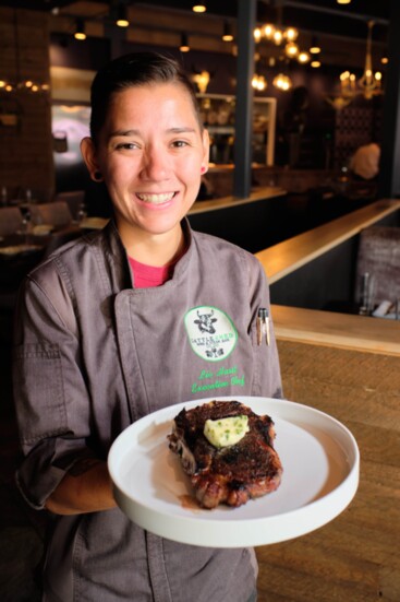 Chef Olivia holding the Espresso-rubbed bone-in Kansas City strip