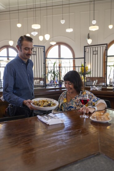 Server Thomas Hughes delivers the penne pasta dish.