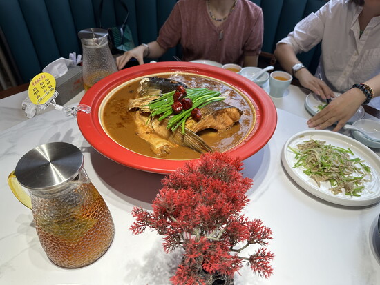 A shared fish dish for lunch served continental style on a lazy Susan, Beijing, China. 