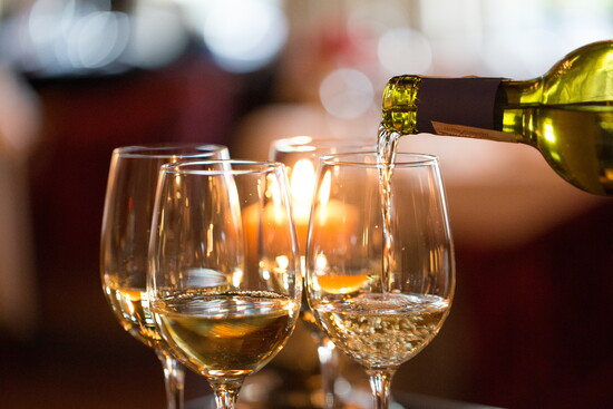 Glasses of white wine being poured. 