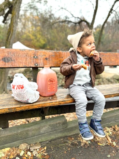 August Taft Batts Linder, son of Nia Batts and Patrick Linder, tucks into cider donuts.