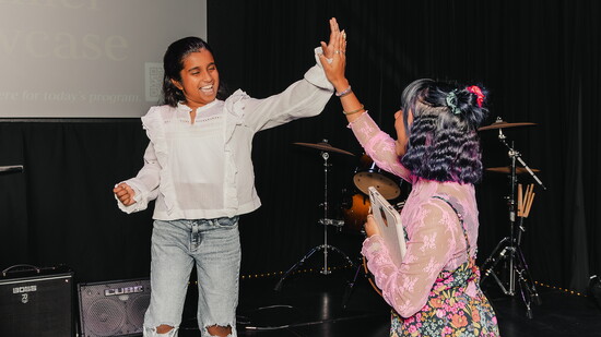 Student and instructor at New Song School of the Arts celebrate a successful run on stage.