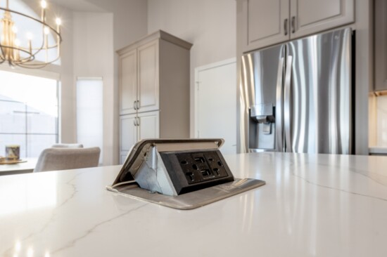 Electrical socket hidden in the island countertop.