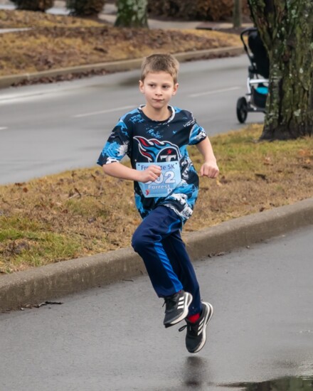 A young fun runner races to the finish.