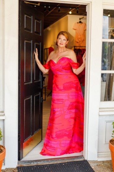 Nichole Holmes wearing an off the shoulder pink and red gown from the Rene Ruiz collection with Stefanie Somers earrings.