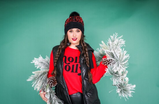 Black puffer vest by Mauritius.  Red “Holly Jolly” sentiment sweater.  Black faux leather jegging by RD International. 