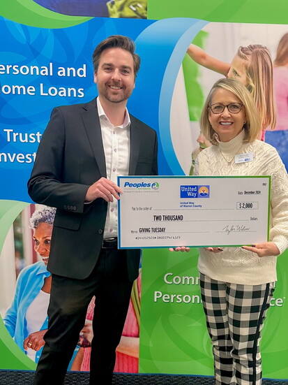 Board Member, Cory Youngs with Peoples Bank, presenting a check from the 2024 campaign to Executive Director, Jane Conn. 