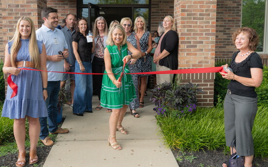 Jane Conn cutting the ribbon at the ribbon cutting ceremony for the new United Way of Warren County location.