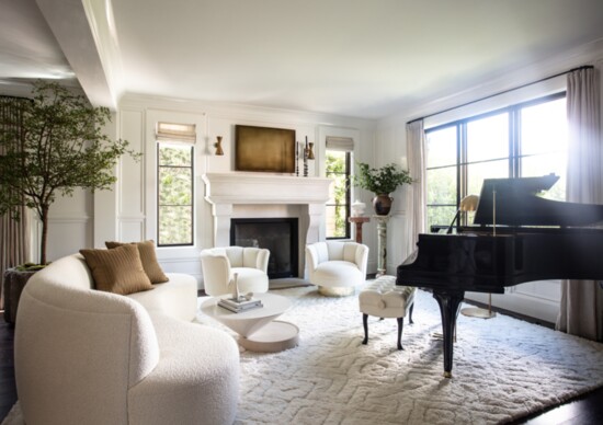 The formal living room features a custom curved sofa, vintage Milo Baughman lounge chairs and a coffee table by Luca Nichetto for De La Espada