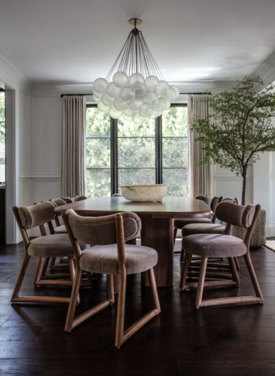 An Apparatus Cloud chandelier hangs over the custom dining table 