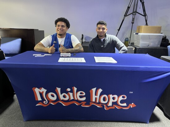 Bryan Villanueva and José Ayala man a table at Iglesia Mana Del Cielo during the Loudoun Hispanic Townhall with Attorney General Jason Miyares