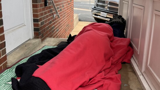 A homeless girl sleeps in the portico in front of Mobile Hope’s offices; the food truck found 115 people in line.