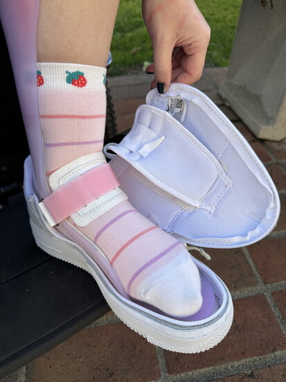 A person with an AFO fitting into an accessible shoe