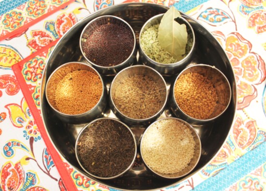 Meera's spice boxes flavor the dishes she uses to give back to her community. 