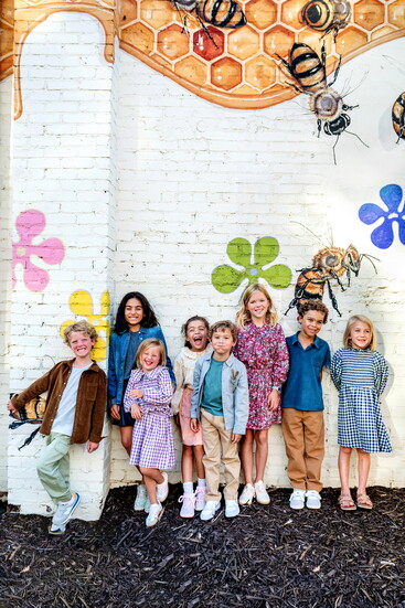 Second from right: Mac is wearing Emile et Ida polo and Morley trousers, to his right Rose is dressed in A Monday in Copenhagen Elin dress in estate blue check