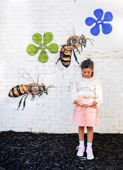 Nora is wearing a Bebe Organic Isabella blouse and Emile et Ida corduroy skirt in pink 