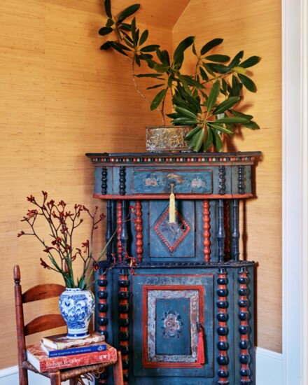 An antique hand-painted Swedish corner cabinet from Kim Faison Antiques was one of the first pieces Sherman found for the cottage. 