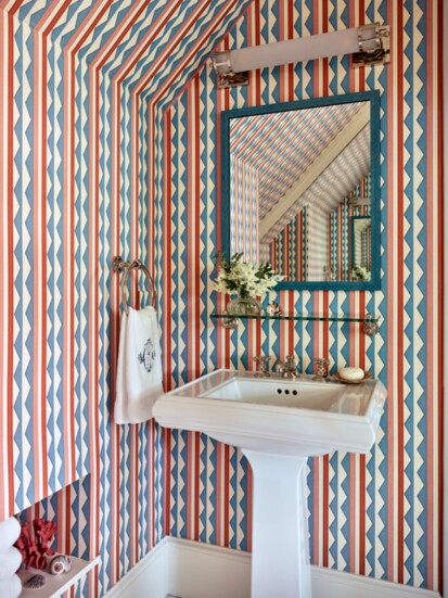 The bathroom wallpaper, Ottoline’s “Bloomsbury Stripes”, maintains the primary color scheme of the cottage. 