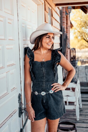 Black denim ruffle romper - silver/turquoise western belt - off white hat with clear crystal band.