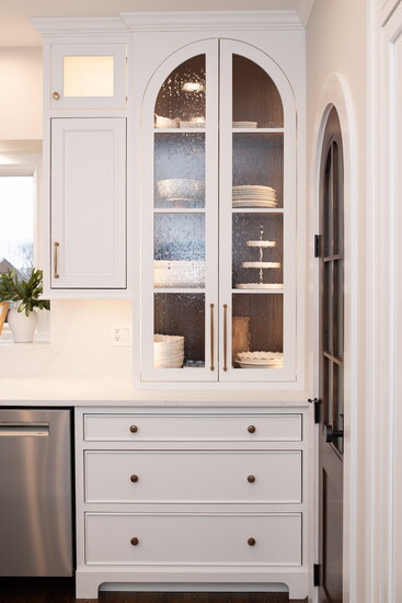 The BTR team built custom arched cabinetry flanking the sink, featuring decorative glass from The Glass Guru Mason. 