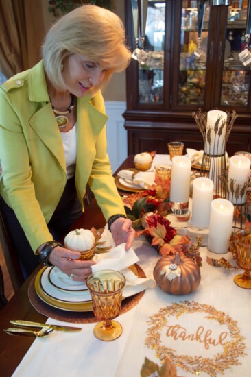 Design assistant Susan Caldwell finishes a place setting.