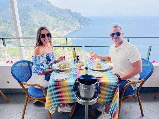 Andy and Nikki enjoying a picture-perfect lunch with a breathtaking view on their Italian getaway.