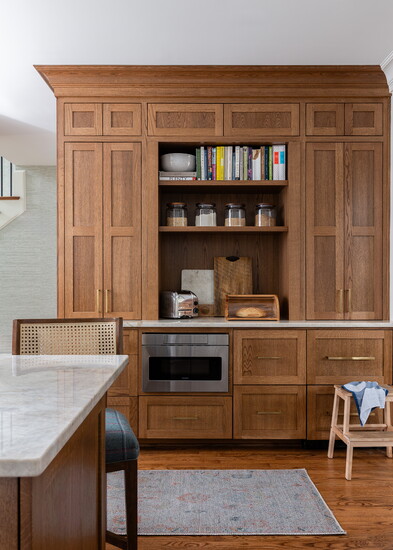 The stained cabinets offer a traditional feel, while the shaker-style doors match the architecture of the Arts and Crafts style house