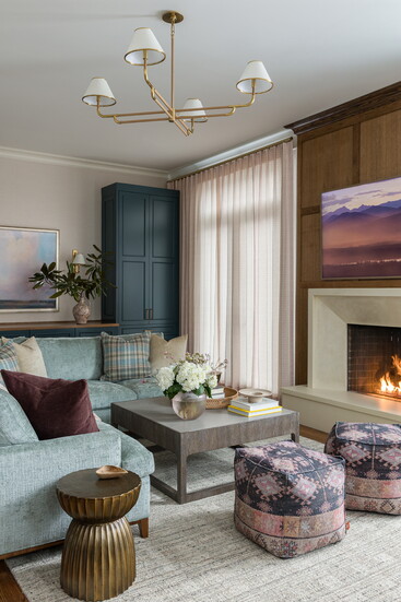 A Charles Stewart sectional sofa is covered in a chenille fabric. Poufs by Loloi.