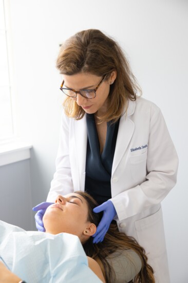 Dr. Smith examines a teen patient's skin.