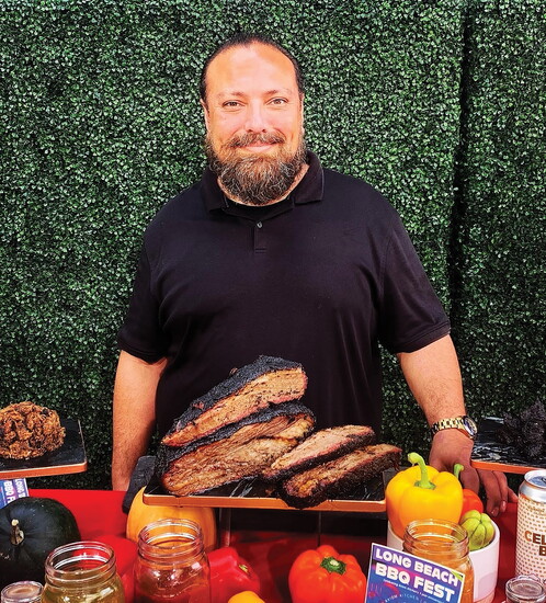 Ian Mafnas poses with brisket at a previous Long Beach BBQ Festival.