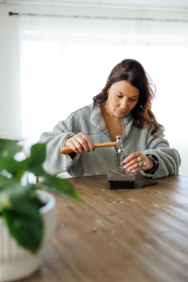 Seen here hammering her business name stamp and 925 stamp onto a sheet of Sterling Sliver, Lovejoy begins a new piece of jewelry for Silver Gypsy. 