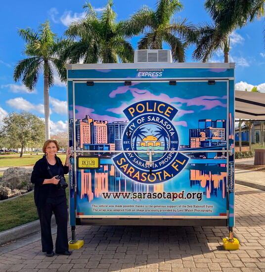 Venice photographer Liesl Walsh stands next to the Sarasota Learning Center trailer that features her reimagined photography. 