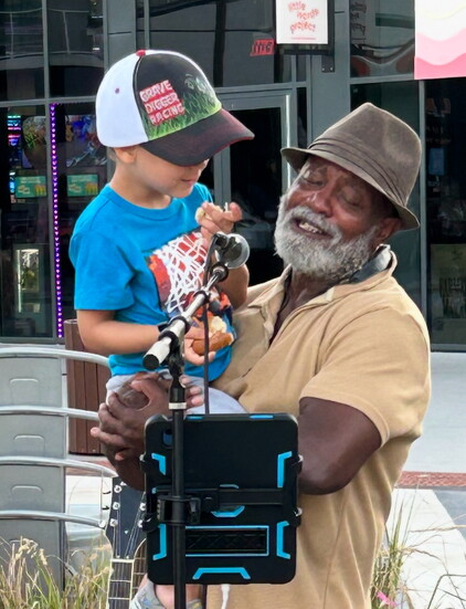 Jeffier Lamar singing to a toddler in the audience 